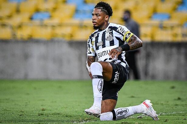 Marinho com a camisa do Santos, ajoelhado no gramado