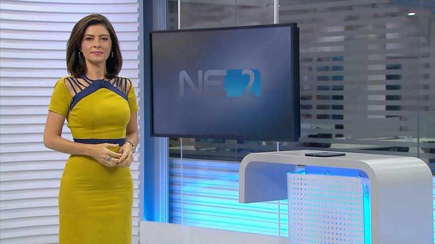 Meiry Lanunce vestido amarelo apresentado o NE2, em frente ao telão nos estúdios da Globo Nordeste