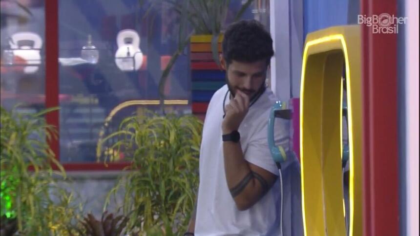 Rodrigo em pé próximo ao Big Fone do BBB 22.