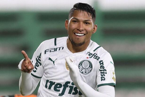 Rony comemorando gol com a camisa do Palmeiras indicando os dedos pro alto