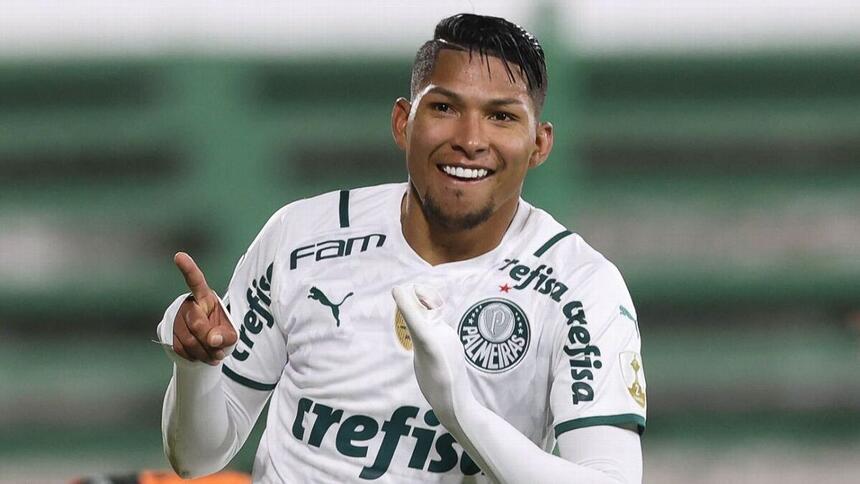 Rony comemorando gol com a camisa do Palmeiras indicando os dedos pro alto