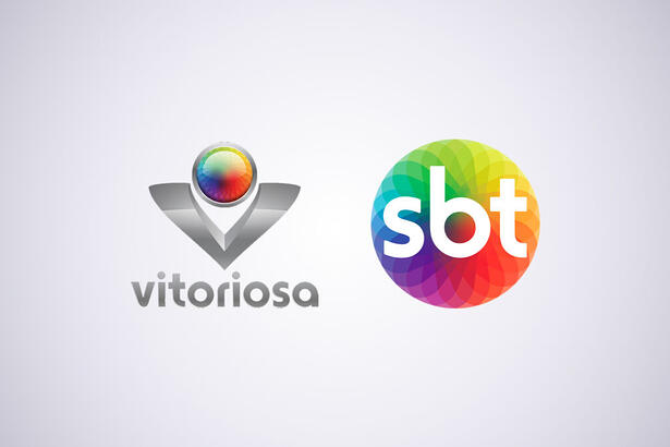 Logo da TV Vitoriosa, ao lado do logo do SBT