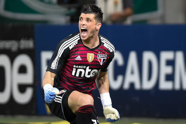 Tiago Volpi celebrando uma defesa no gol do São Paulo com so braços abertos