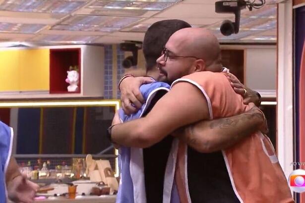 Tiago de colete laranja, abraça Pedro Scooby por ficar com a liderança, após venceram a prova no BBB 22.