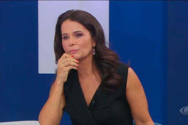 Adriana Araújo com a mão por cima da bancada do programa Canal Livre