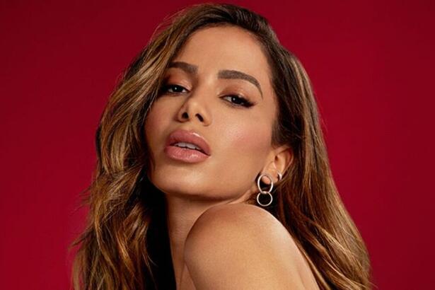 Anitta posa para foto com fundo vermelho