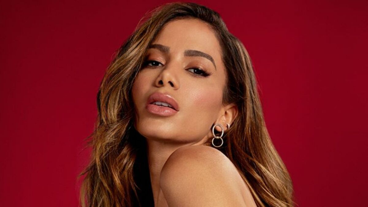 Anitta posa para foto com fundo vermelho