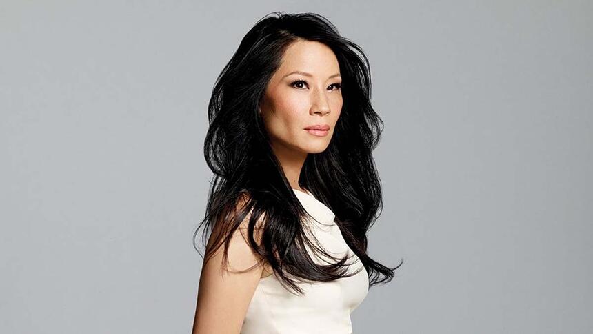 Lucy Liu em um fundo branco, e cabelos soltos