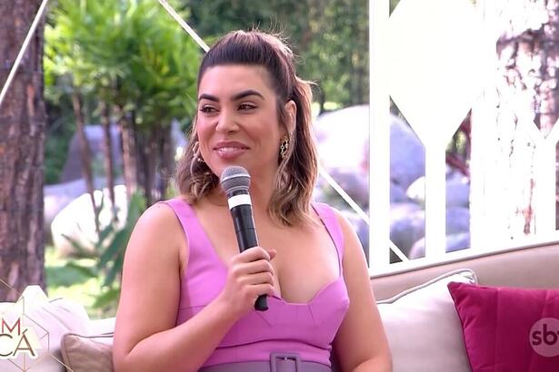 Naiara Azevedo de vestido rosa sentada no sofá do programa Vem Pra Cá