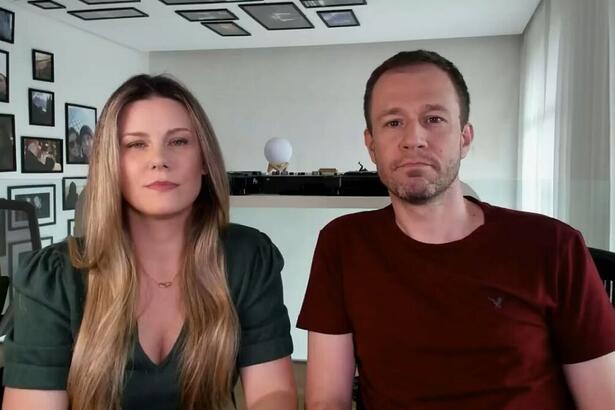 Daiana Garbin e Tiago Leifert com semblantes tristes gravando vídeo para falar sobre a filha Lua