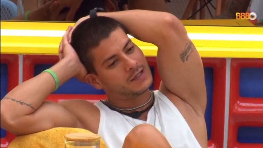 Arthur Aguiar sentado na mesa da cozinha do VIP no BBB 22