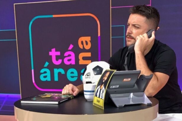 Igor Rodrigues falando no telefone em bastidores do programa Tá na Área, do SporTV