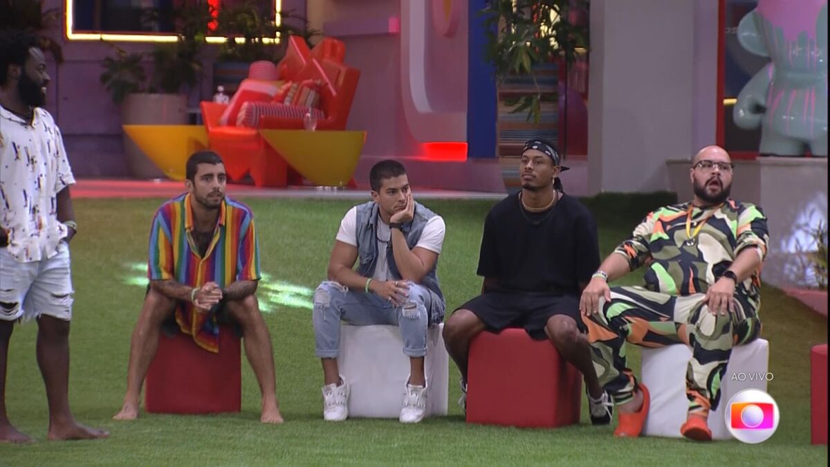 Douglas em pé, Pedro Scooby, Arthur Aguiar, Paulo André e Tiago Abravanel sentados, no gramado onde aconteceu o Jogo da Discórdia