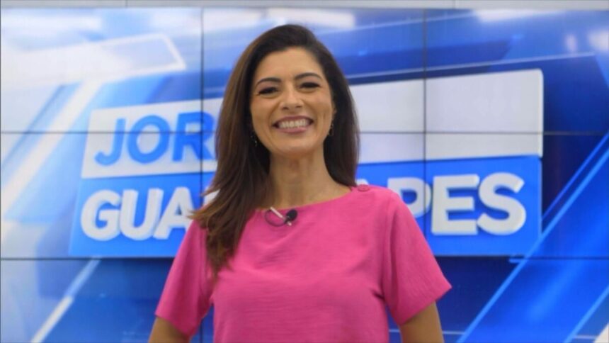 Meiry Lanunce vestido um blusa rosa, durante chamada da estreia do Jornal Guararapes, gravada no estúdio