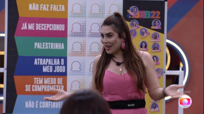 Naiara Azevedo em pé de frente ao quadro do jogo da discórdia do BBB 22