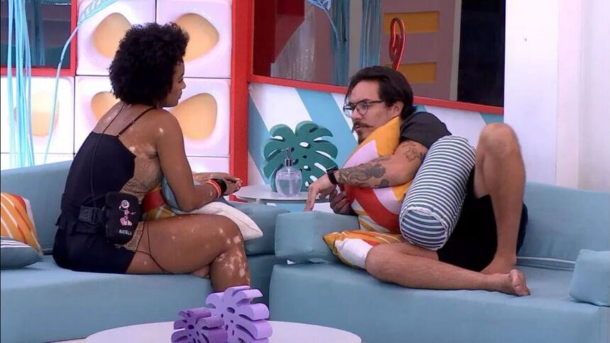 Natália sentada de frente para Eliezer na área externa do BBB 22.