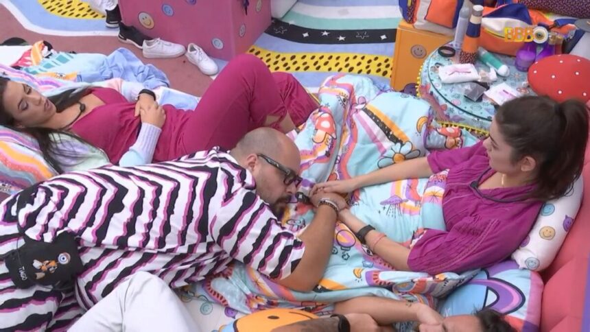 Tiago Abravanel deitado no colo de Eslovênia e Larissa ao lado, no quarto lollipop do BBB 22