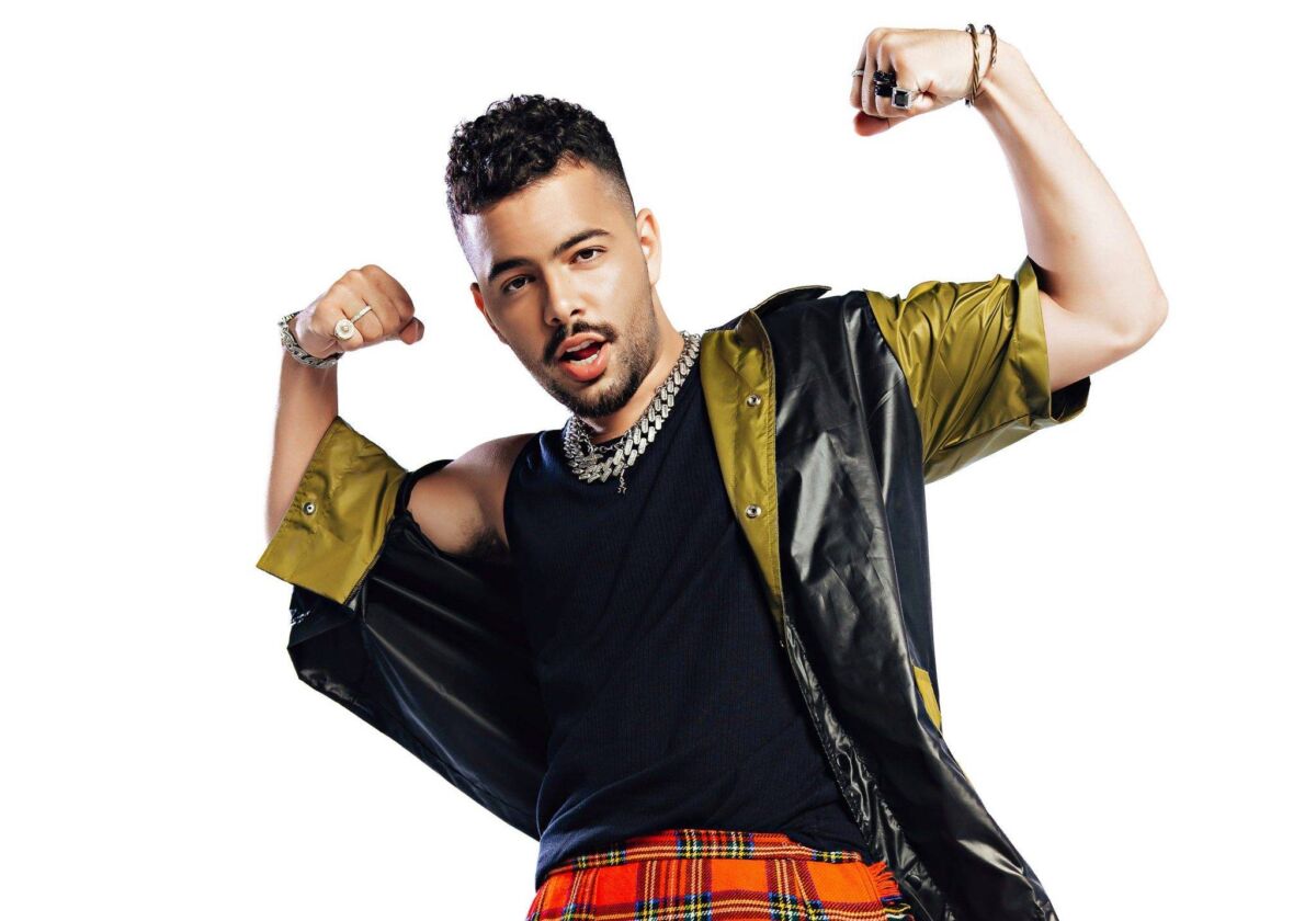 Pedro Sampaio lança primeiro álbum intitulado de Chama Meu Nome, cantor está vestido com camiseta preta, casaco e saia vermelha