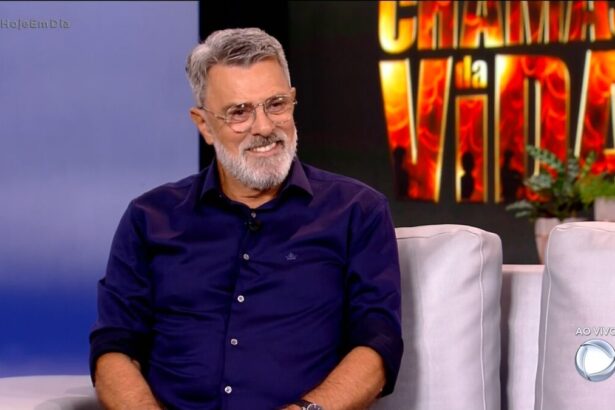 Raymundo de Souza sentado no sofá do programa Hoje em Dia. Por trás está um telão com o logo da novela Chamas da Vida que o ator foi divulgar