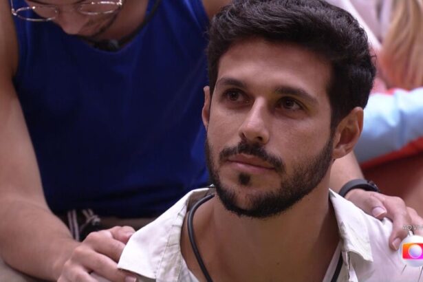 Sentado no chão da sala, Rodrigo escuta discurso de Tadeu Schmidt antes de ser eliminado no BBB 22