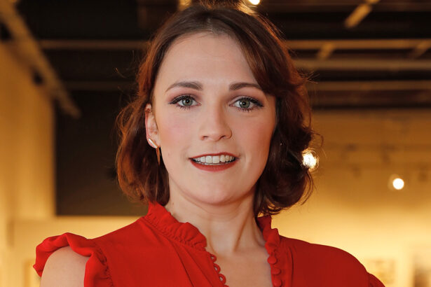 Charlotte Ritchie, de vestido vermelho, sorri