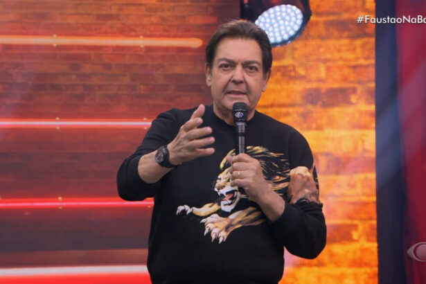 Fausto Silva no palco do seu programa na Band, apresentador veste uma blusa preta