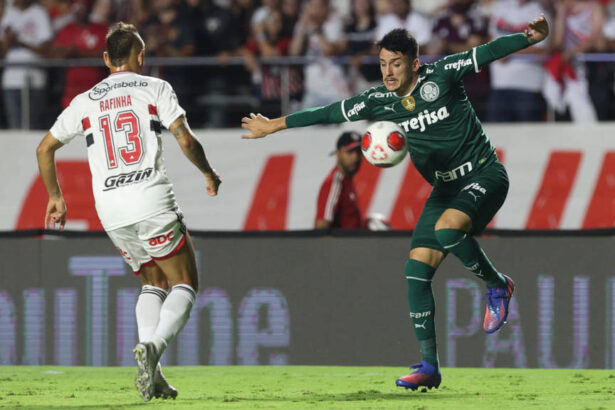 Jogadores de São Paulo e Palmeiras em campo, disputando uma bola, pela final do Paulistão