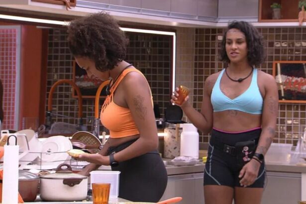 Linn de top azul próxima de Jessilane na cozinha da xepa do BBB 22.