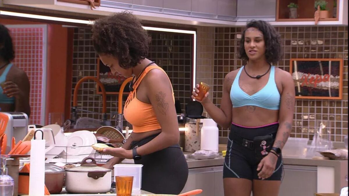 Linn de top azul próxima de Jessilane na cozinha da xepa do BBB 22.