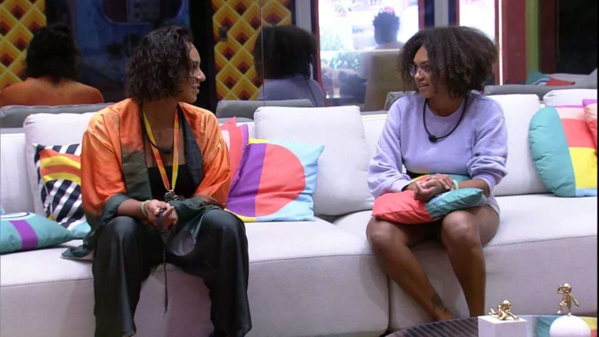 Jessilane de camiseta de mangas compridas sentada ao lado de Linn no sofá do BBB 22.