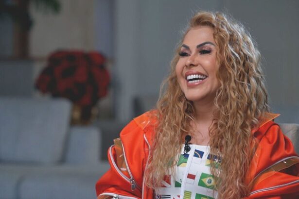 Joelma sorrindo de casaco laranja