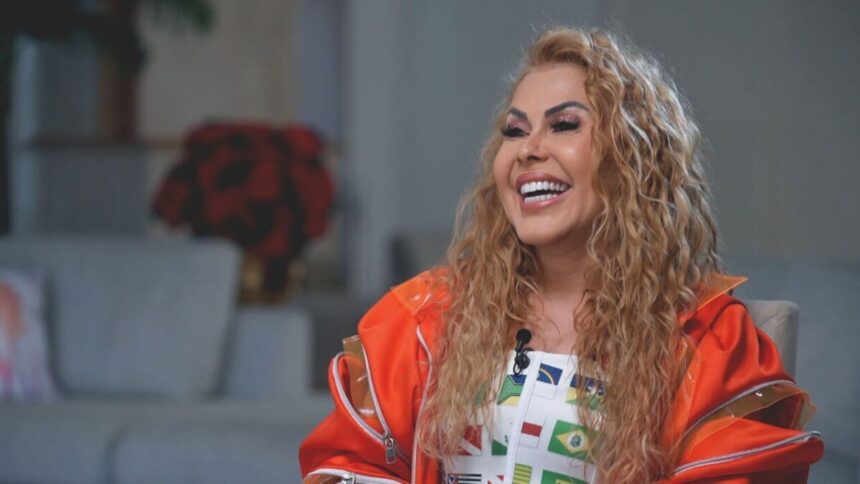 Joelma sorrindo de casaco laranja