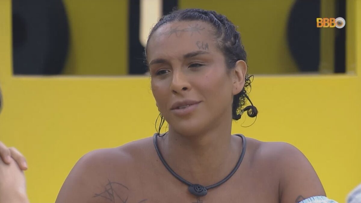Linn da Quebrada sentada na mesa almoçando com Lucas no BBB 22