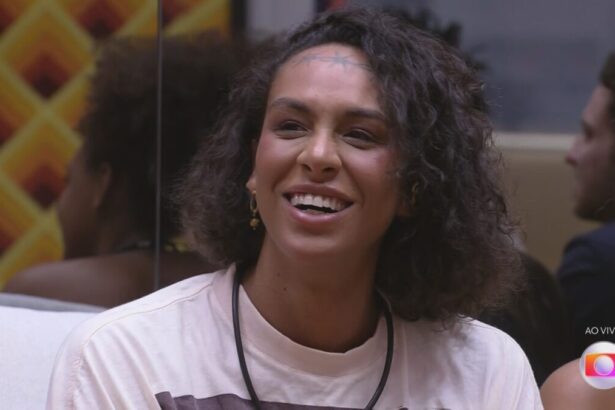 Linn da Quebrada sorrindo no sofá da sala do BBB 22