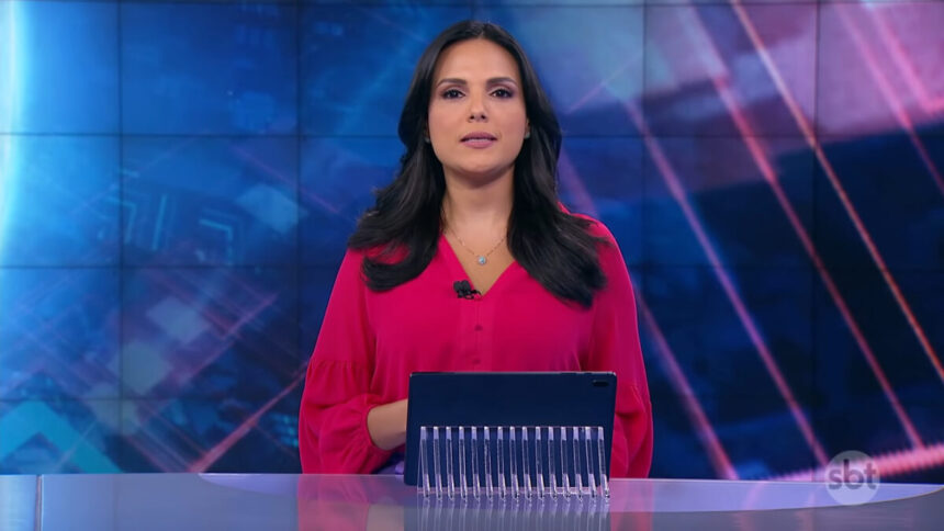 Márcia Dantas, com uma blusa rosa, sentada na bancada do SBT Brasil - edição de 18 de março de 2018