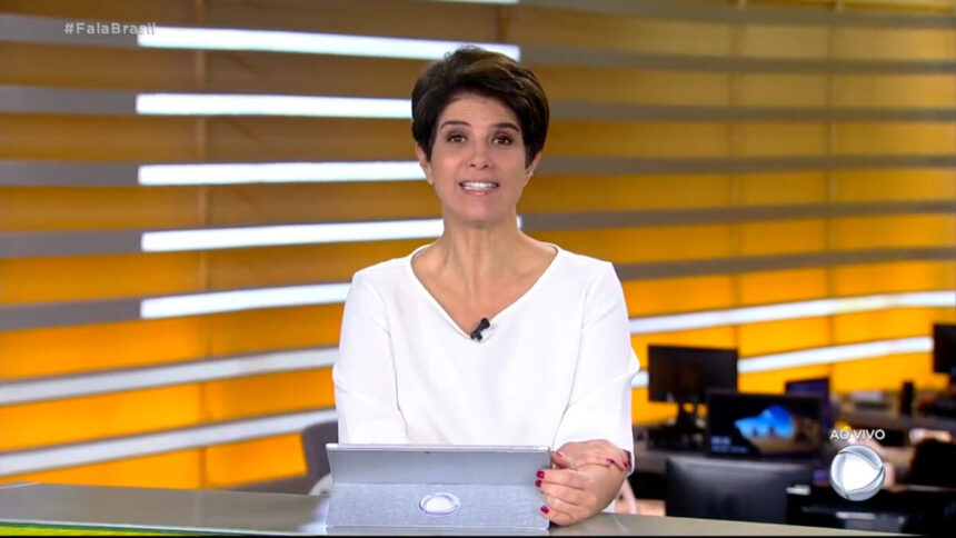 Mariana Godoy com uma blusa branca, sentada na bancada do Brasil, durante a edição de 11 de março de 2022