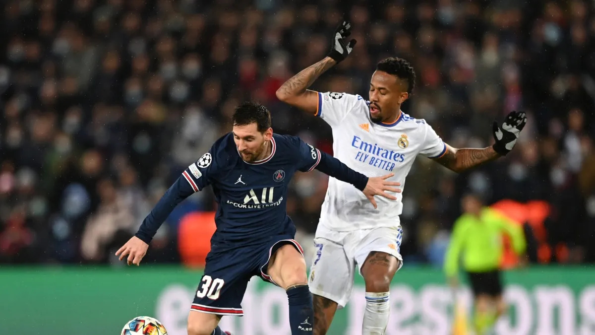 Brasileiro Militão (Real Madrid) disputando bola com Messi (PSG) em jogo pela Liga dos Campeões