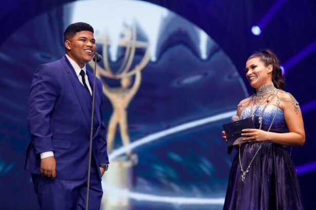 Paulo Neto, de terno azul, recebendo o prêmio no palco do evento