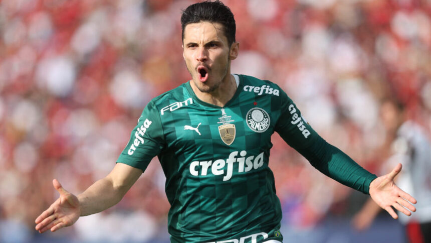 Raphael Veiga comemorando um gol com a camisa do Palmeiras, de braços abertos