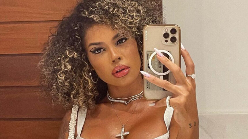 Sthe Matos em um selfie no espelho no banheiro com o celular em uma das mãos a mostra