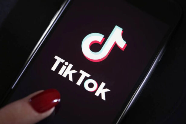 Logo do TikTok em um celular, com um dedo sobreposto