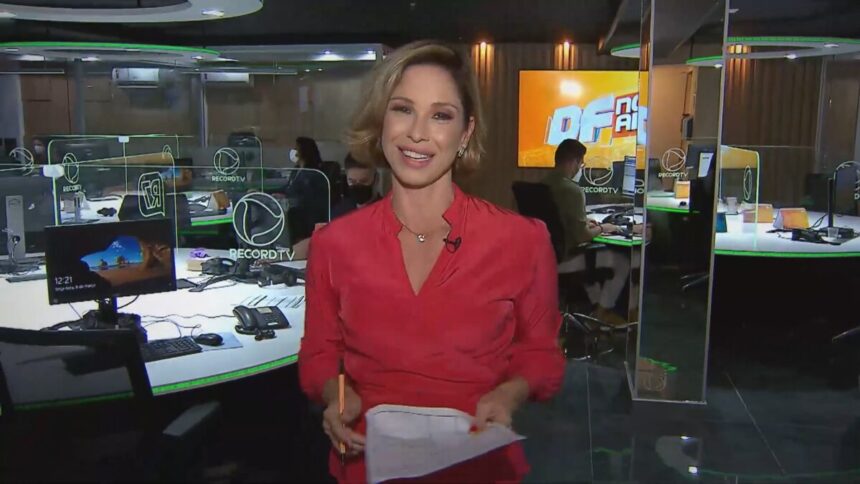 Neila Medeiros caminho no meio da redação da Record TV Brasília