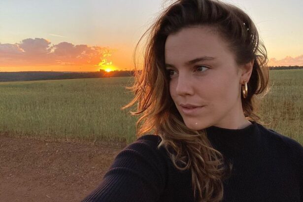 Alice Wegmann em foto posada com um pôr do sul ao fundo