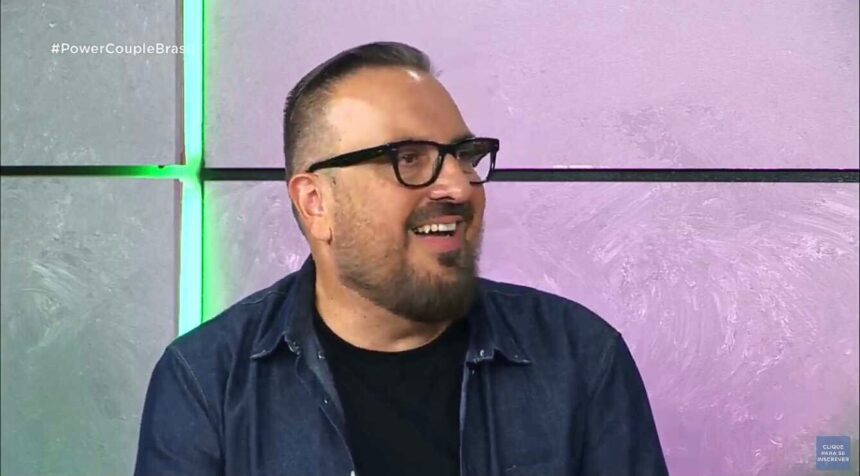 Rodrigo Carelli sorrindo durante coletiva do Power Couple Brasil 6.