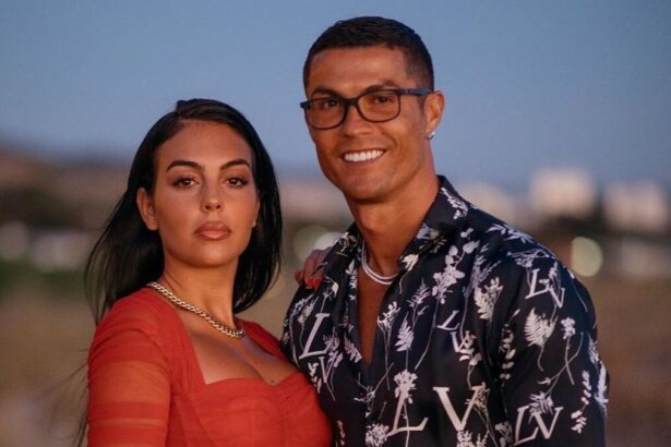 Cristiano Ronaldo e Georgina Rodríguez, abraçados em foto posada. Craque utiliza um óculos