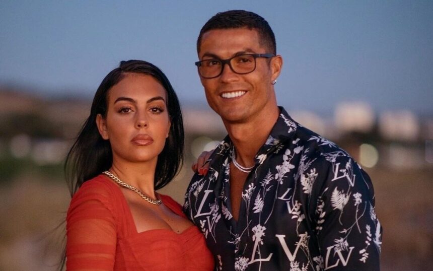 Cristiano Ronaldo e Georgina Rodríguez, abraçados em foto posada. Craque utiliza um óculos