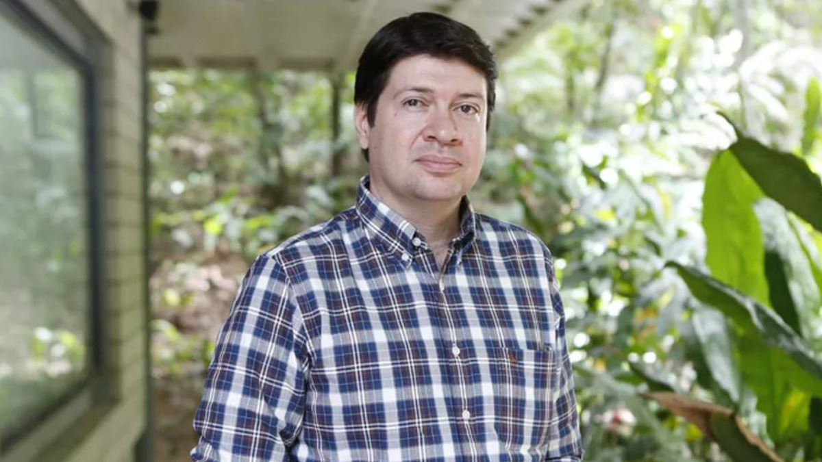 Daniel Adjafre em foto posada na Globo, com um jardim ao fundo