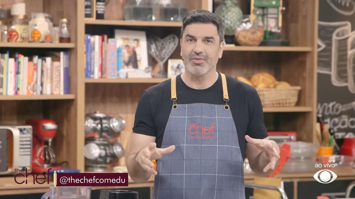 Edu Guedes vestindo um avental azul nos estúdios do The Chef, na Band