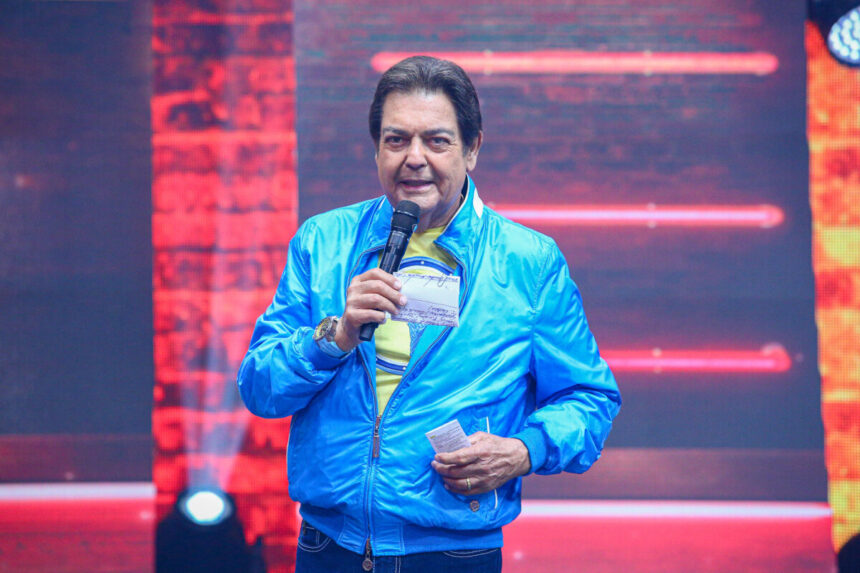 Faustão de casaco azul e microfone na mão