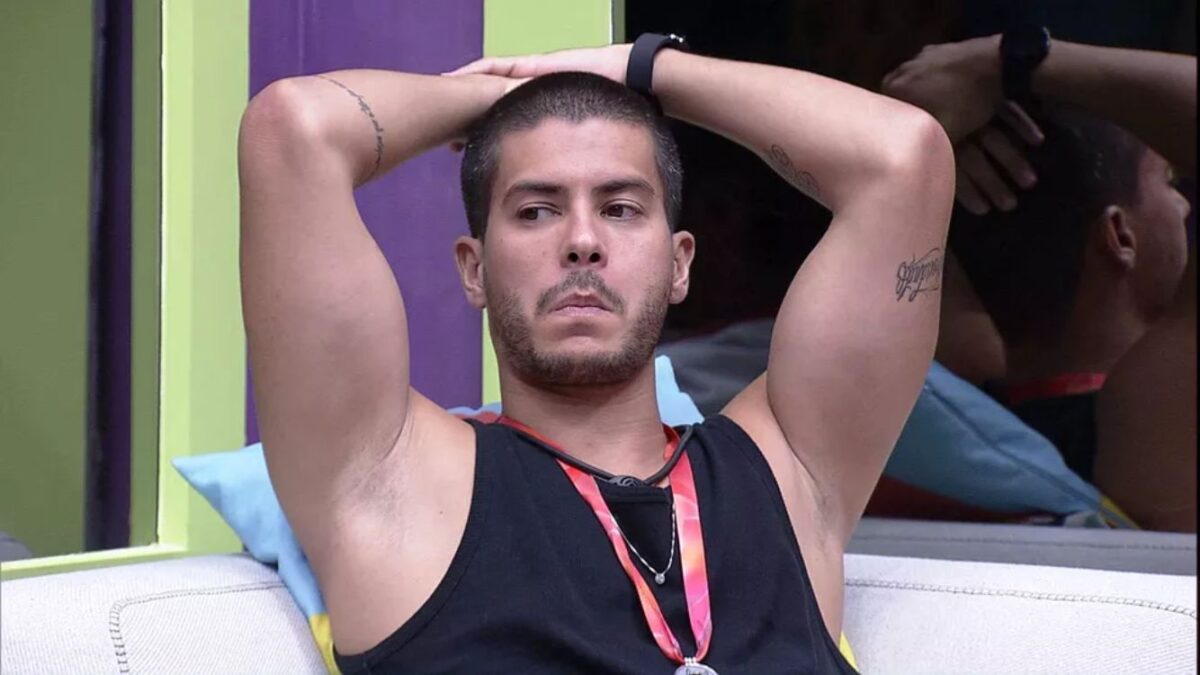 Arthur com os braços na cabeça no sofá do BBB 22.